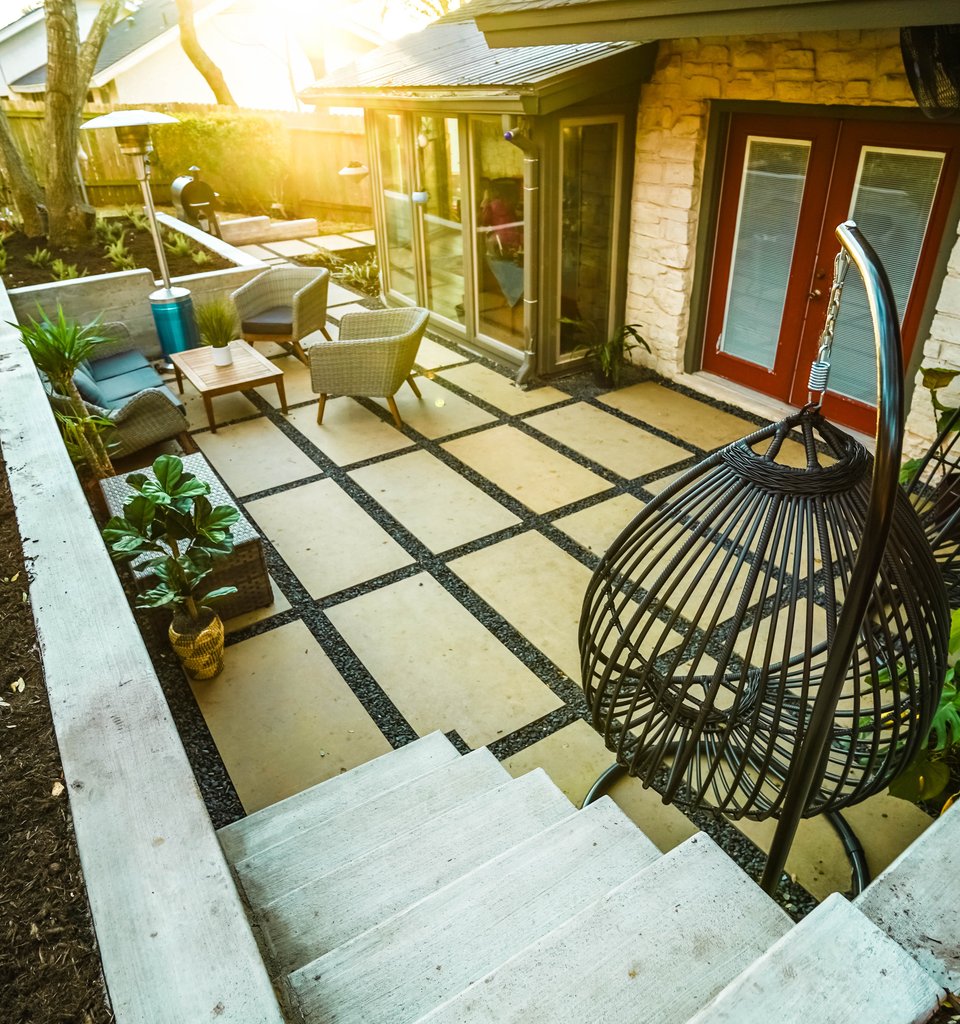 Shoal Creek terraced backyard with board-formed concrete walls and cream paver patios