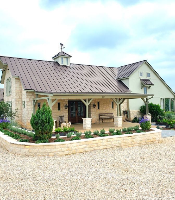 Stone home with limestone retaining walls and native planter beds