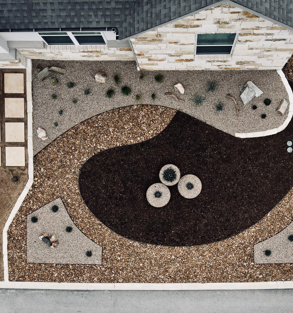 Spicewood front yard xeriscape with cream pavers, gravel, and native plants