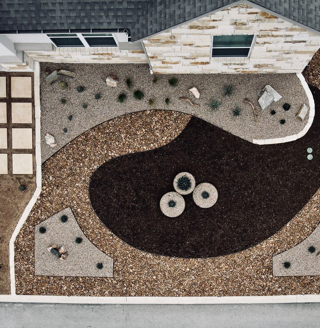 Aerial view of a Spicewood front-yard xeriscape design with gravel, mulch zones, and paver pathways