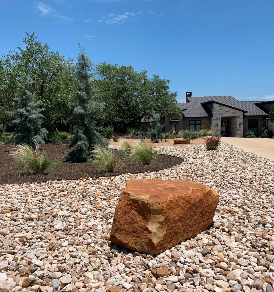 Dripping Springs Hill Country slope lined with river rock to slow and channel stormwater runoff